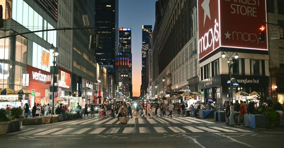 Evening scene at a busy New York intersection with pedestrians and neon lights