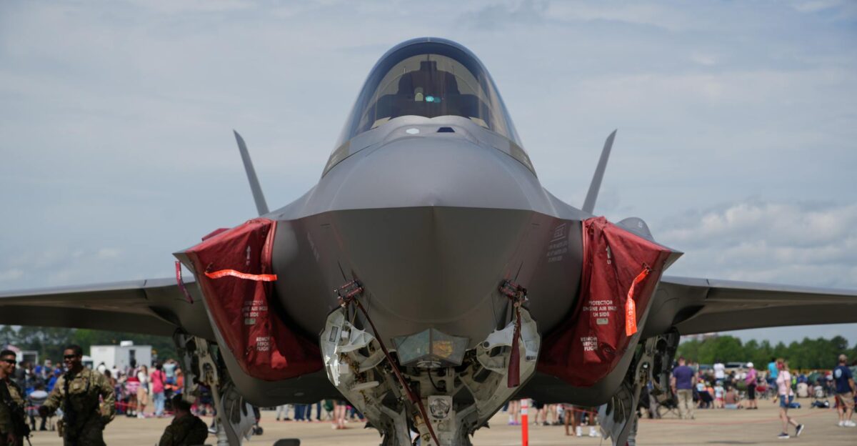 Front view of an F-35 fighter jet on display at an airshow in Hampton Virginia with military personnel nearby