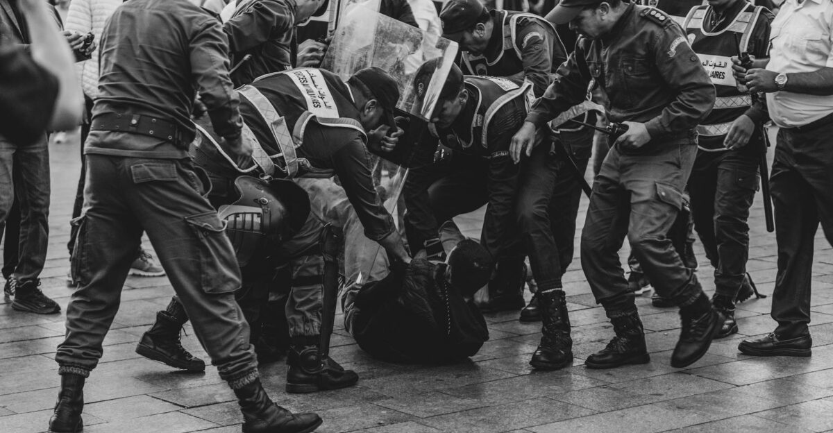 A group of police officers detaining a protester during a demonstration in Rabat Morocco