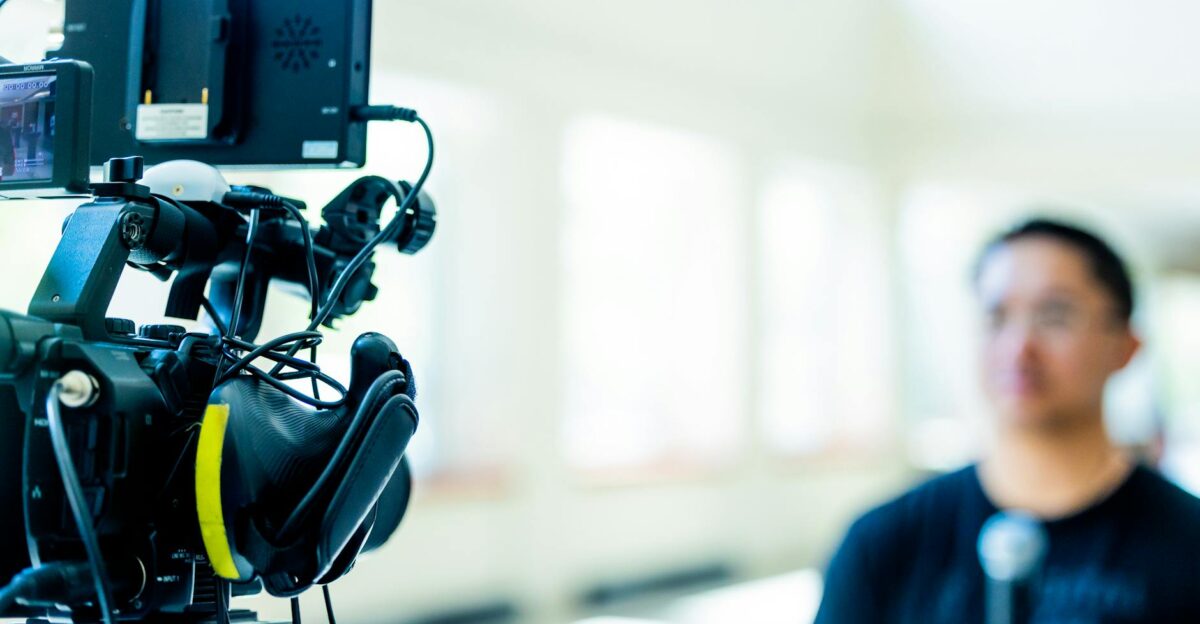Professional video camera setup focusing on an interview with blurred subject in the background