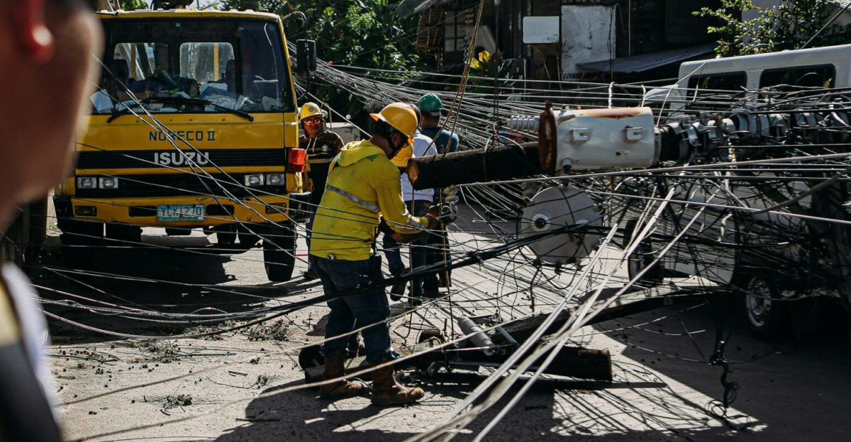 Utility workers assess and fix downed power lines on a sunny day, ensuring safety and service restoration.