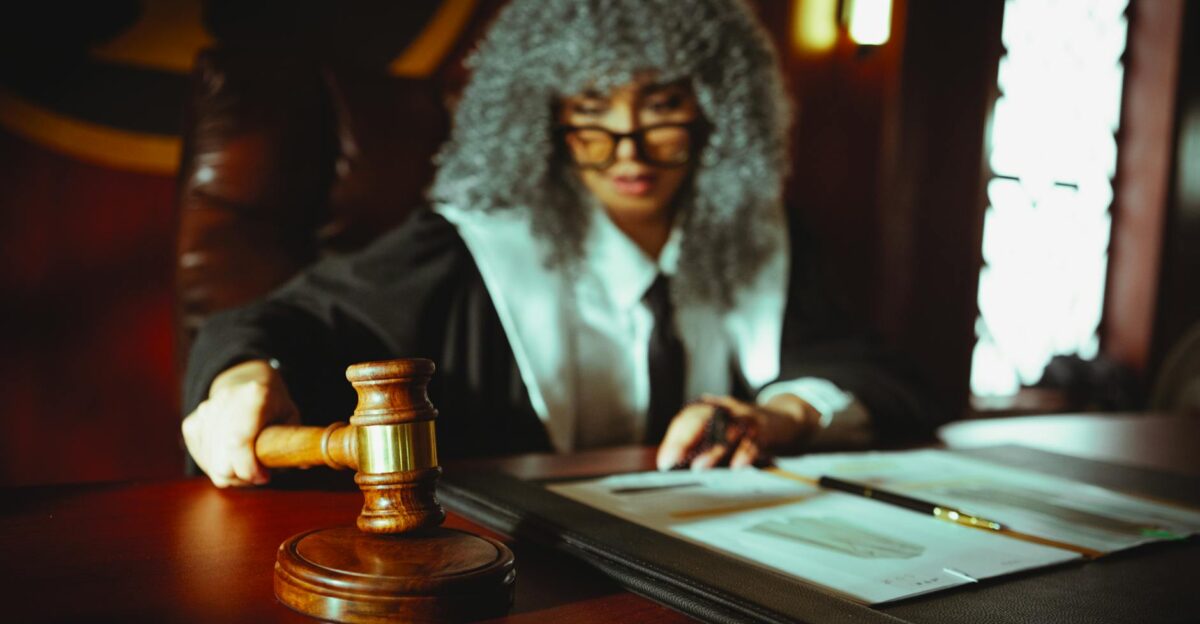 Female judge in a courtroom setting focusing on legal documents with a gavel