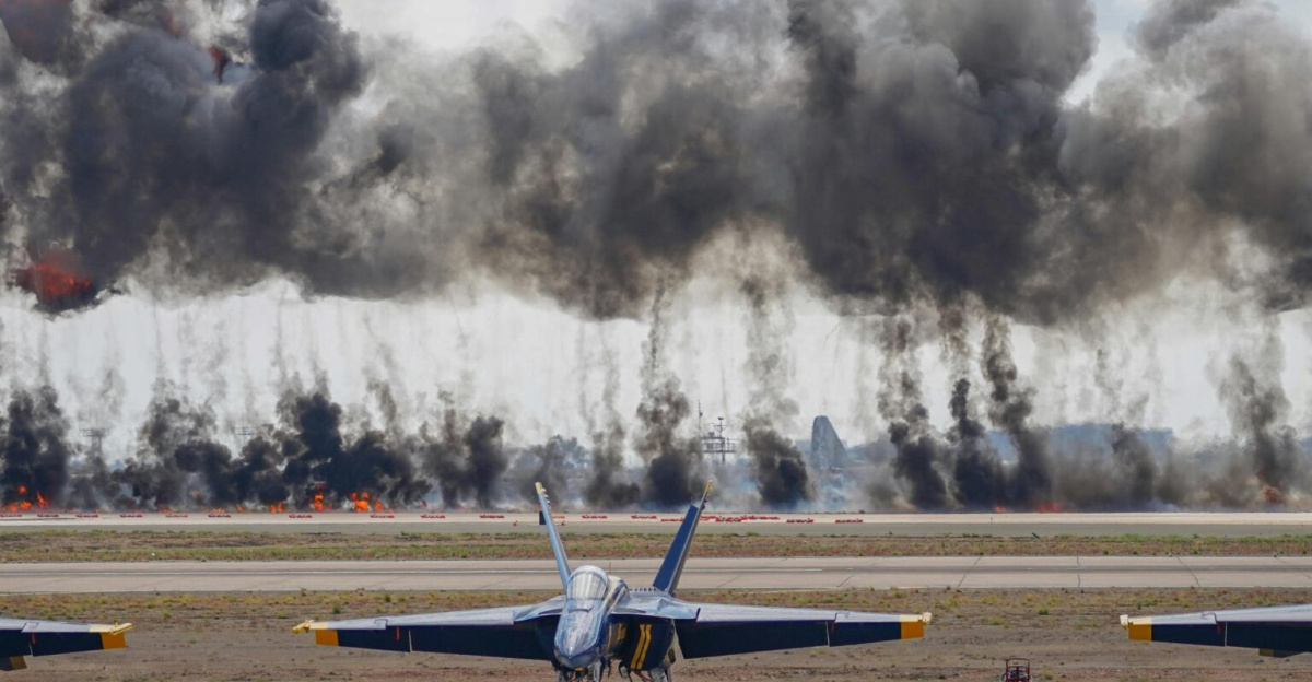 Dynamic scene featuring Blue Angels jets amid smoke and explosions during an airshow demonstration.