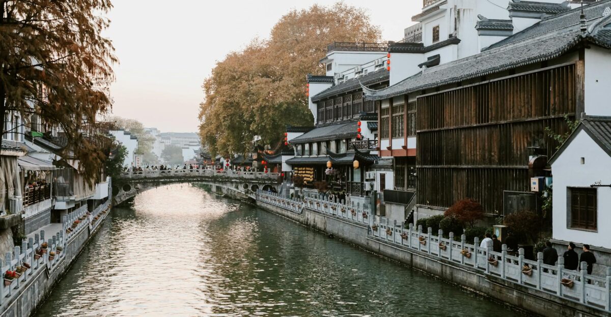 Tranquil scene of a canal lined with traditional Chinese architecture in Nanjing during fall