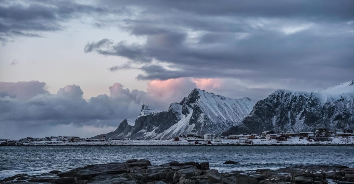 Breathtaking winter seascape of snowy mountains in Lofoten Norway capturing serene beauty and dramatic skies