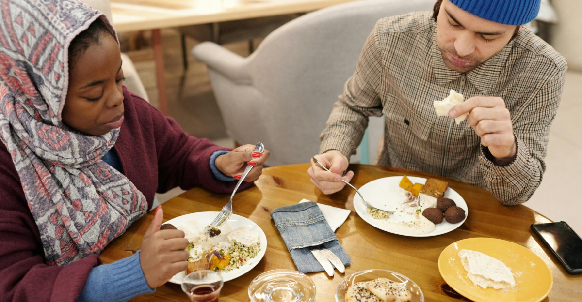 A multiethnic couple dining indoors, enjoying a Middle Eastern meal.