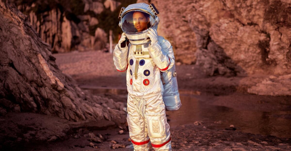 Astronaut in a space suit explores a rocky desert environment at sunset
