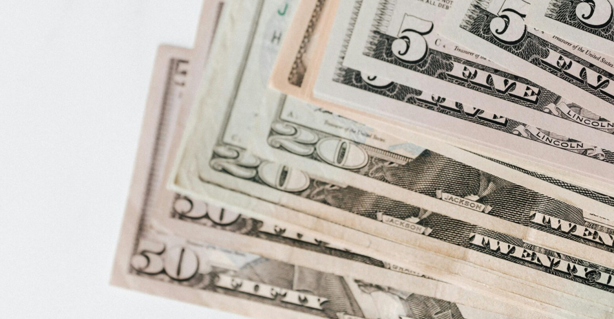 Close-up shot of various US dollar bills on a marble tabletop, showcasing finance and wealth.