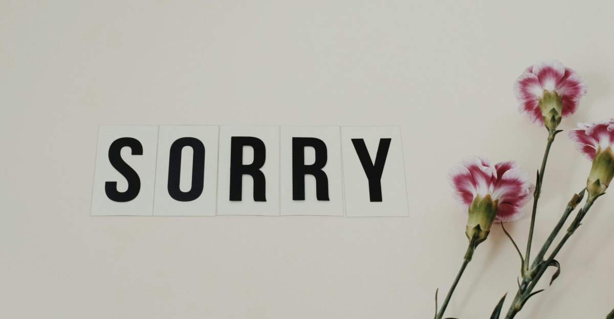 Word 'SORRY' displayed with pink carnations on a white background