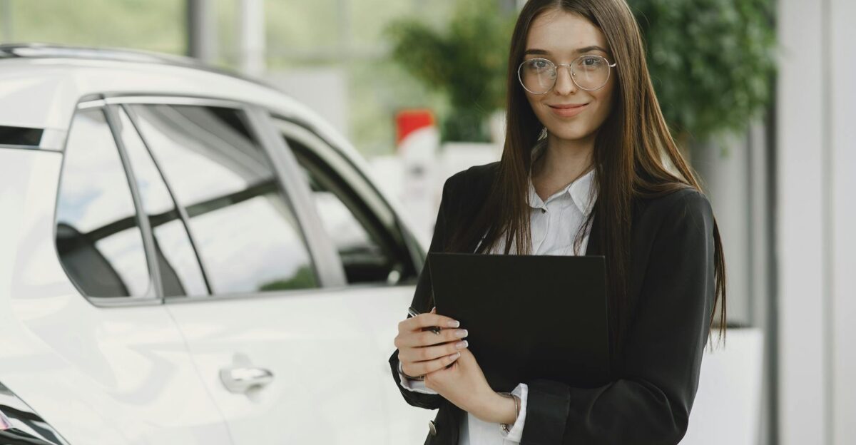 Businesswoman with a clipboard standing beside a car in a modern showroom