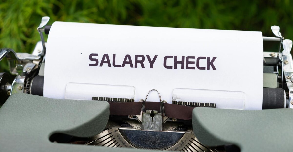 Close-up of a vintage typewriter typing Salary Check on paper symbolizing payroll and finance