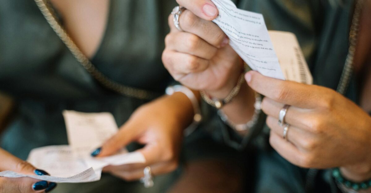 Two individuals reviewing receipts in a close-up scene focusing on payment details