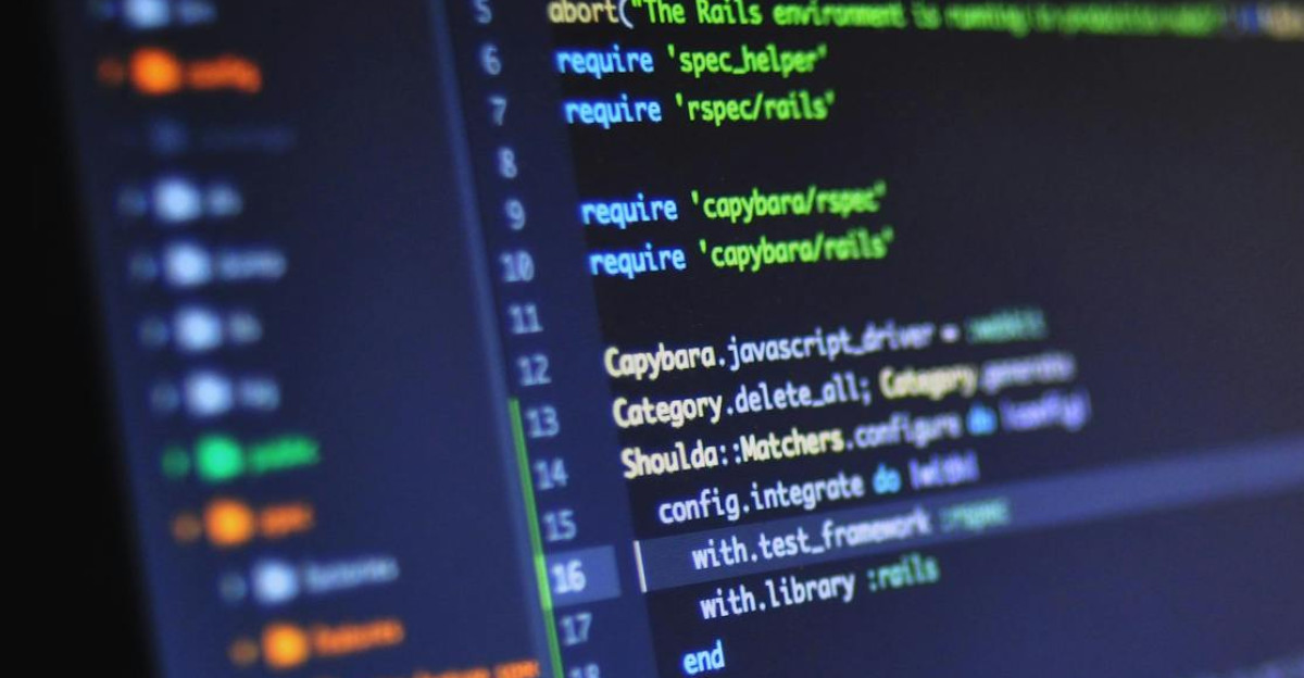Close-up of a computer screen displaying programming code in a dark environment