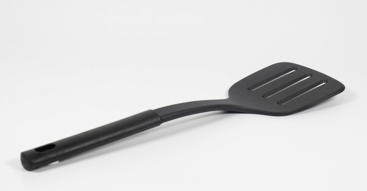 Simple black spatula utensil displayed on a white background with ample copy space.
