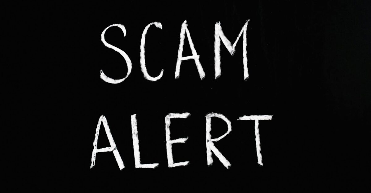 Blackboard with Scam Alert written in white chalk emphasizing a warning concept