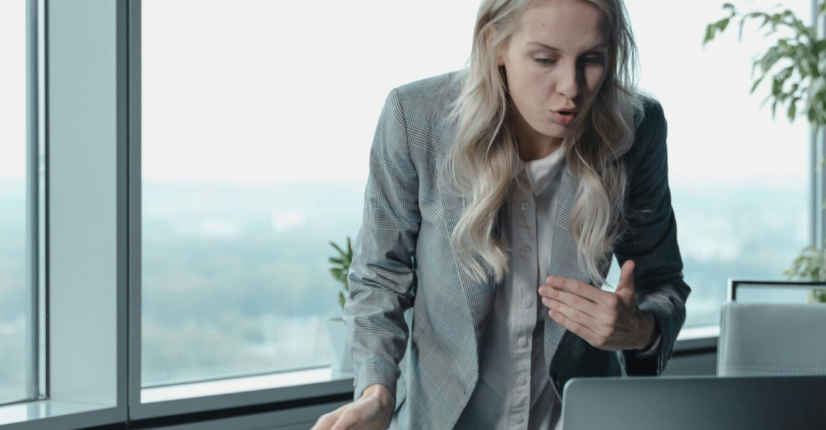 Businesswoman engaging in a video call, demonstrating leadership in a modern office setting.