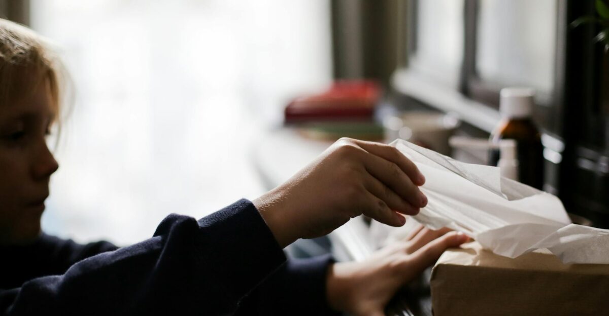 Young child reaching for tissues with medicine on a table illness concept