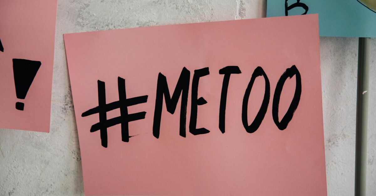 A close-up of a pink protest sign featuring the MeToo message