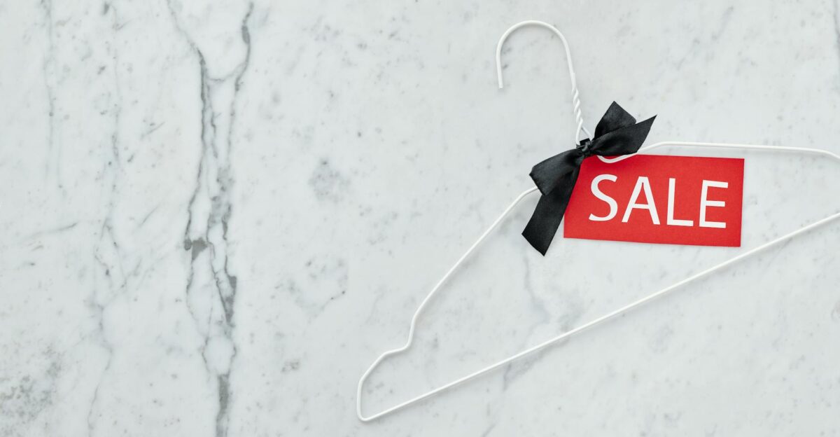 White clothes hanger with sale tag on marble background Perfect for retail promotions