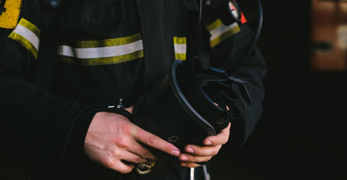 Detailed view of a firefighter s hands holding essential safety equipment showcasing uniform and gear