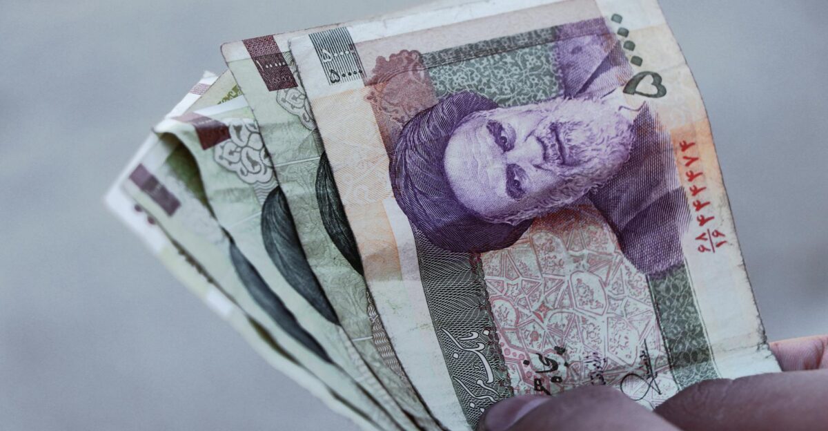 Detailed view of Iranian rial banknotes held in hand illustrating finance and economy in Iran