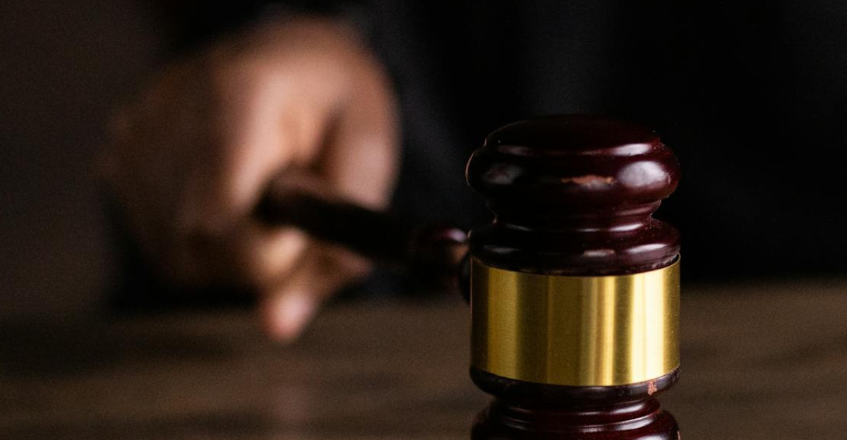 A gavel striking a sound block symbolizing justice and legal authority in a courtroom setting