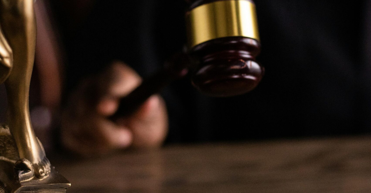 Close-up of a judge holding a gavel, symbolizing justice and law in a courtroom setting.