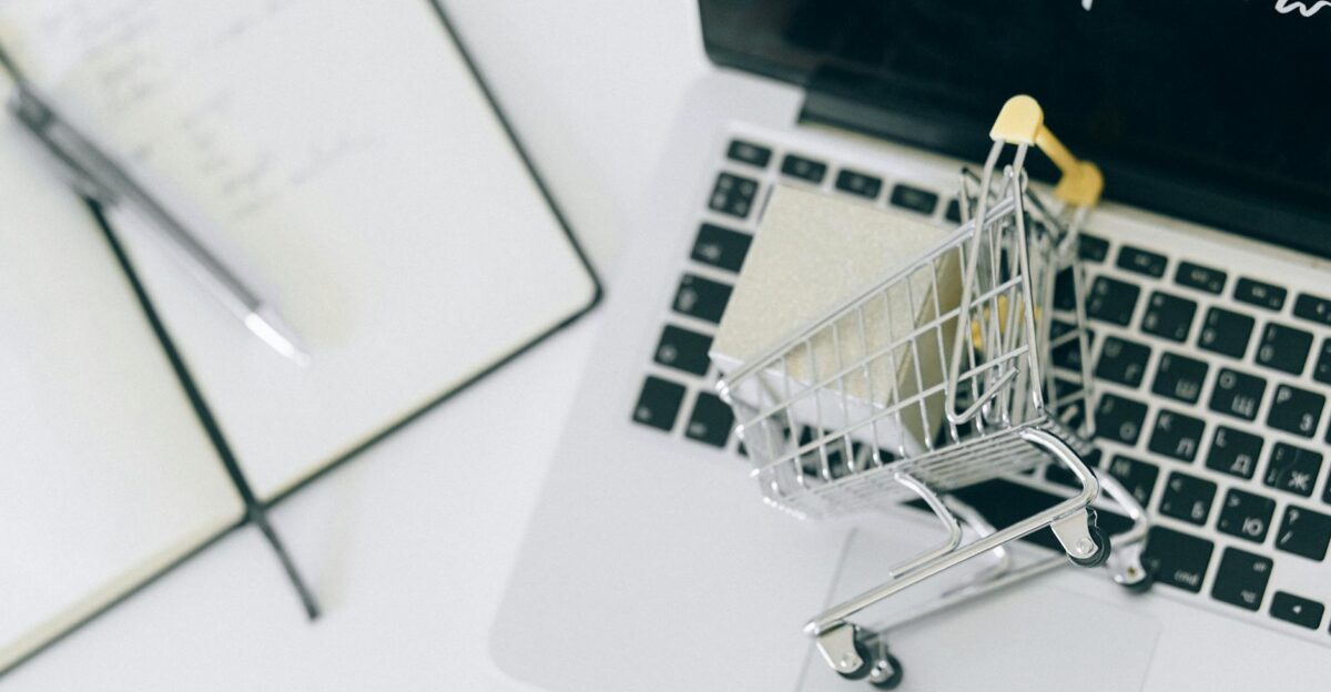 Creative depiction of online shopping with a miniature cart on a laptop keyboard