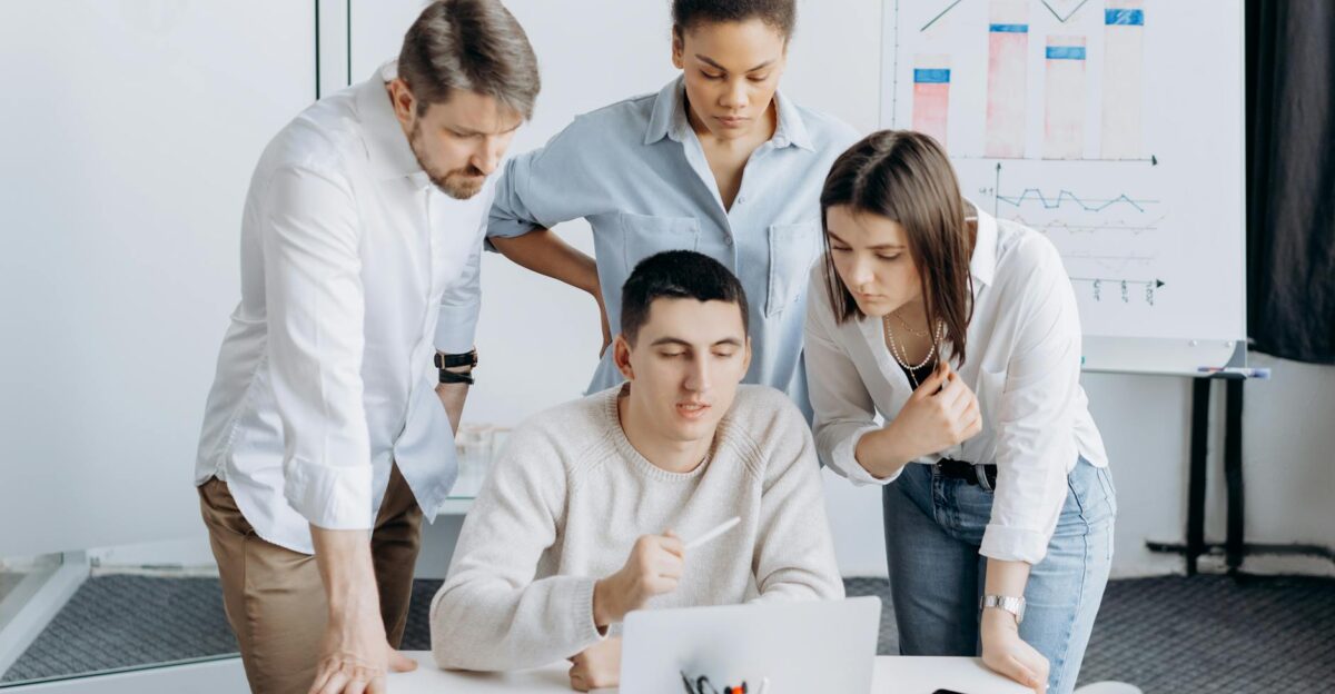 Group of professionals collaborating on a project with graphs in an office setting