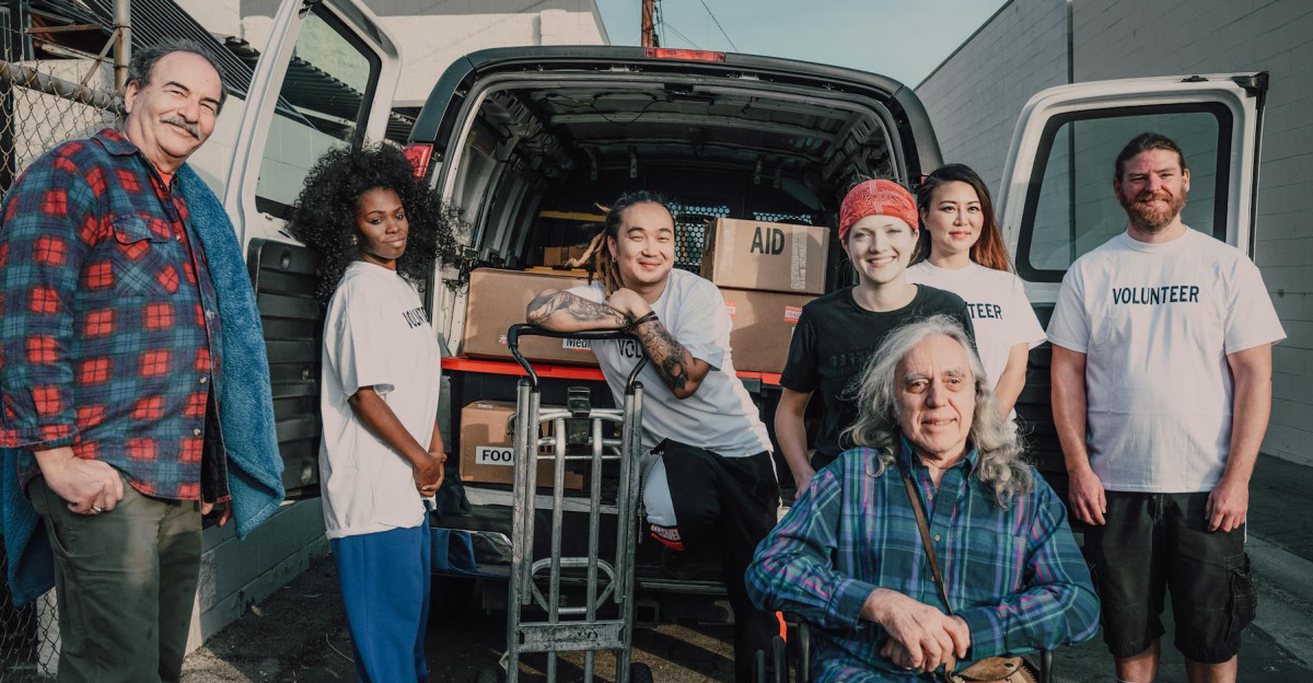 A diverse group of volunteers packing aid supplies into a van for donation