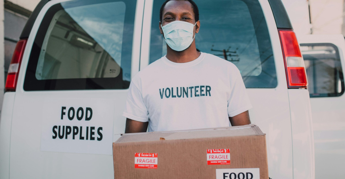 African American volunteer distributing food supplies during relief efforts.