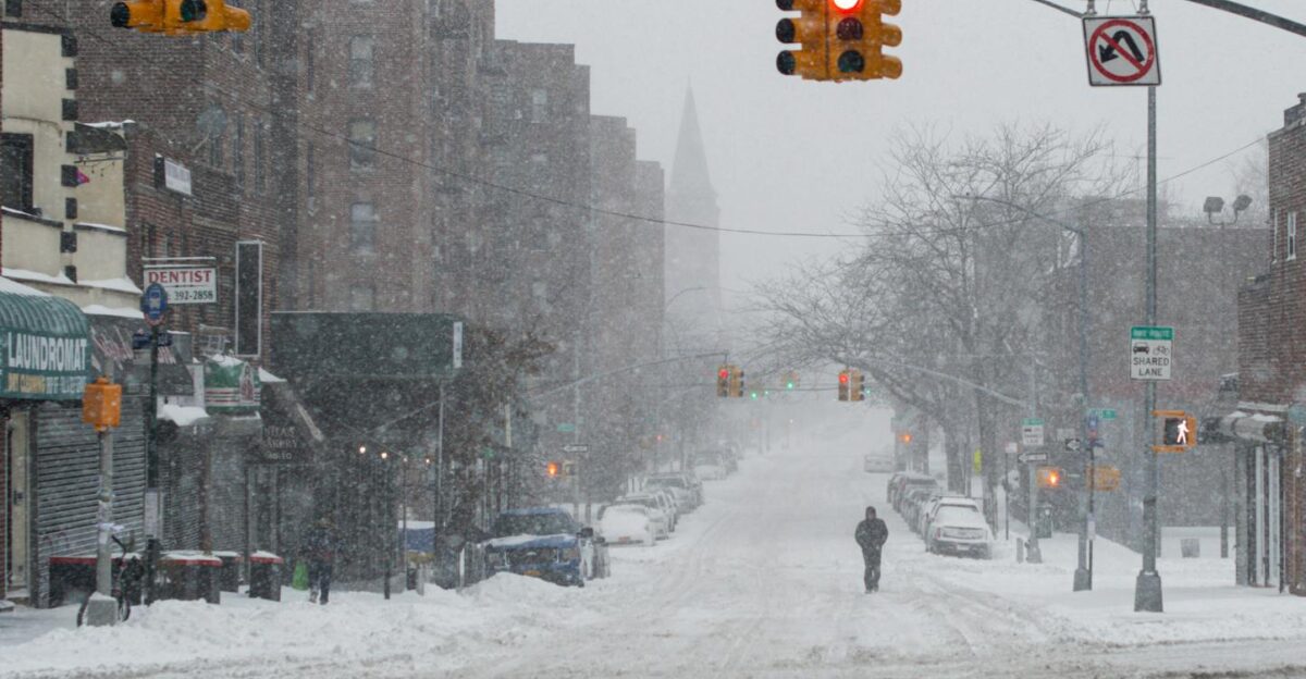 A snow-covered urban street with traffic lights and a lone pedestrian capturing the essence of winter in the city