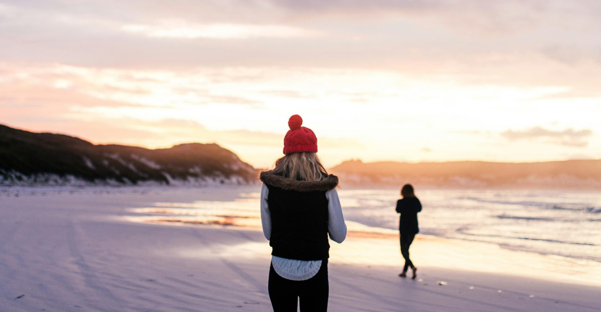 A serene winter beach walk during a beautiful sunset, capturing quiet and reflection.
