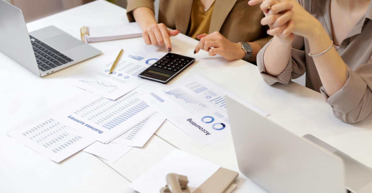 Two professionals collaborating on financial documents in a modern office setting.