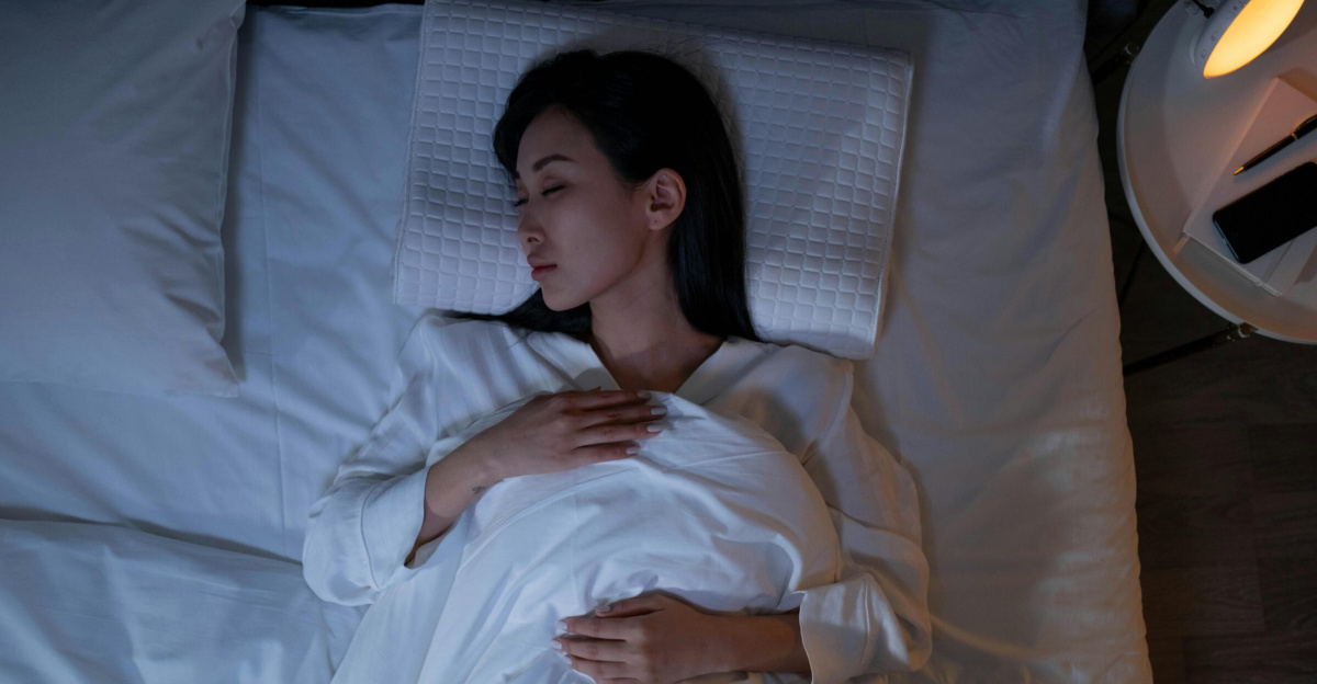 Calm and peaceful woman resting in bed under dim lighting, promoting relaxation.