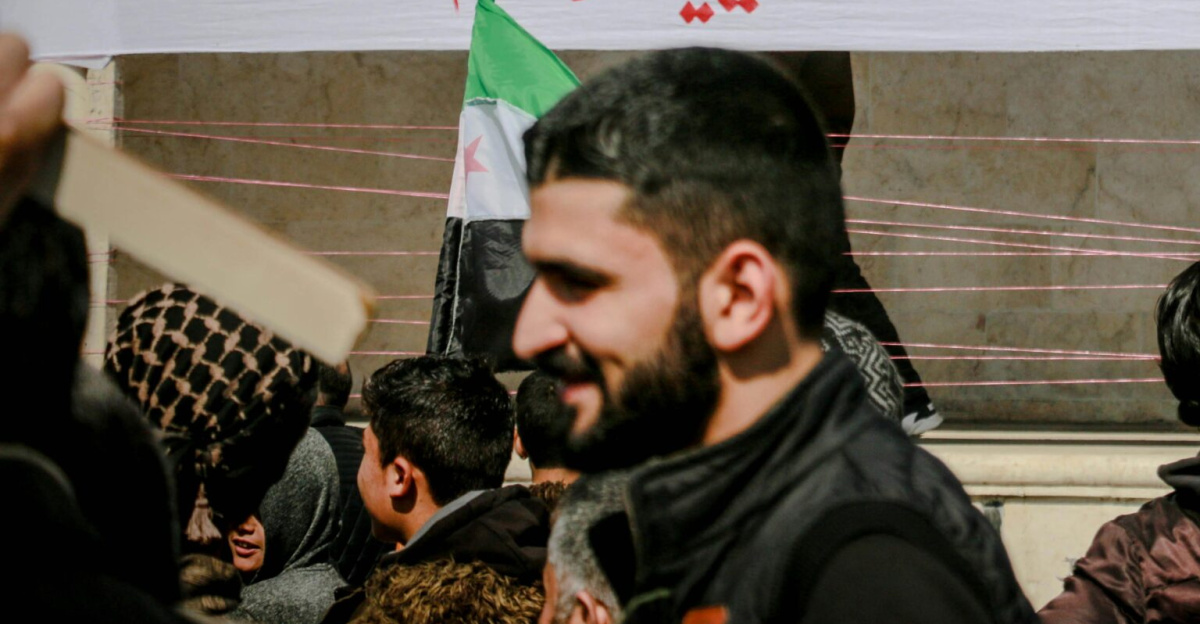Protesters in Idlib, Syria, rally for justice and human rights with banners and flags.