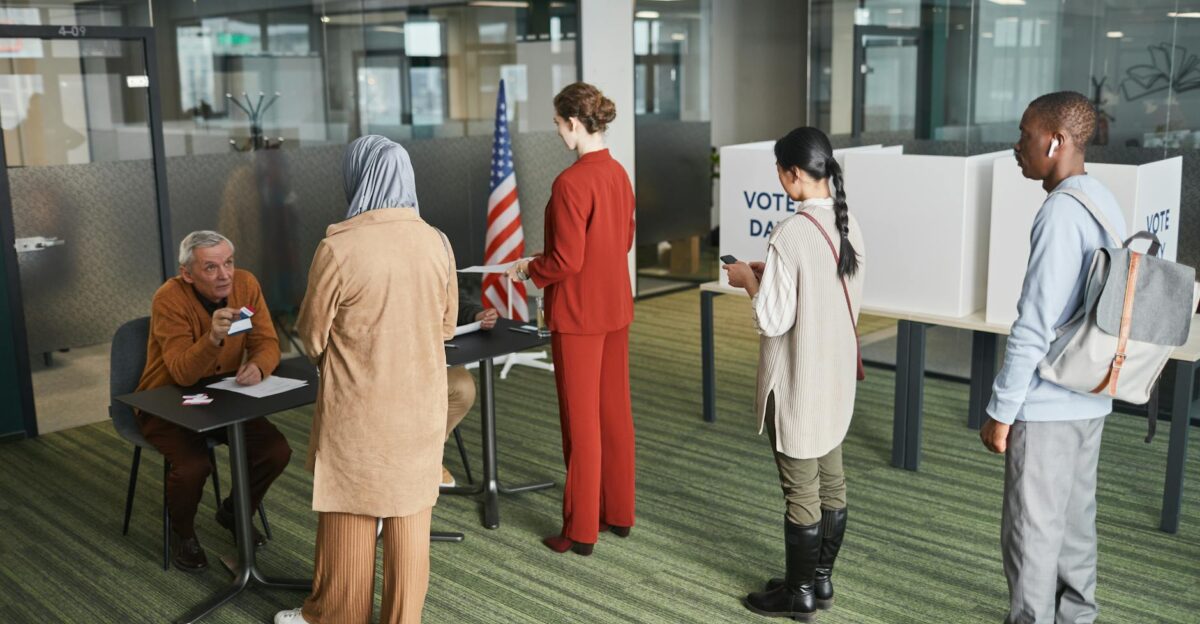 Diverse group of voters lining up at an indoor polling station on election day