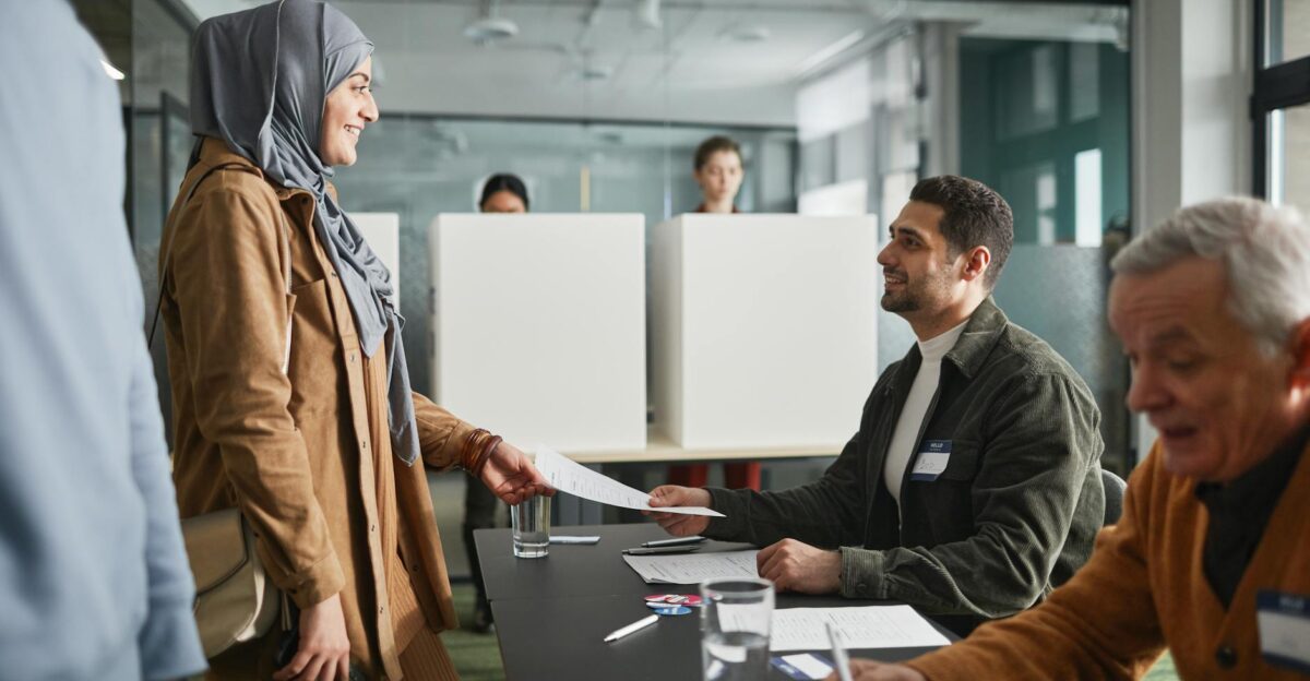 A diverse group of adults participating in voting at an indoor polling station
