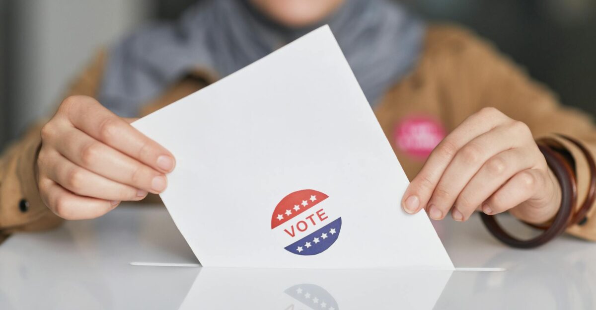 Close-up of hands holding a vote ballot symbolizing election participation