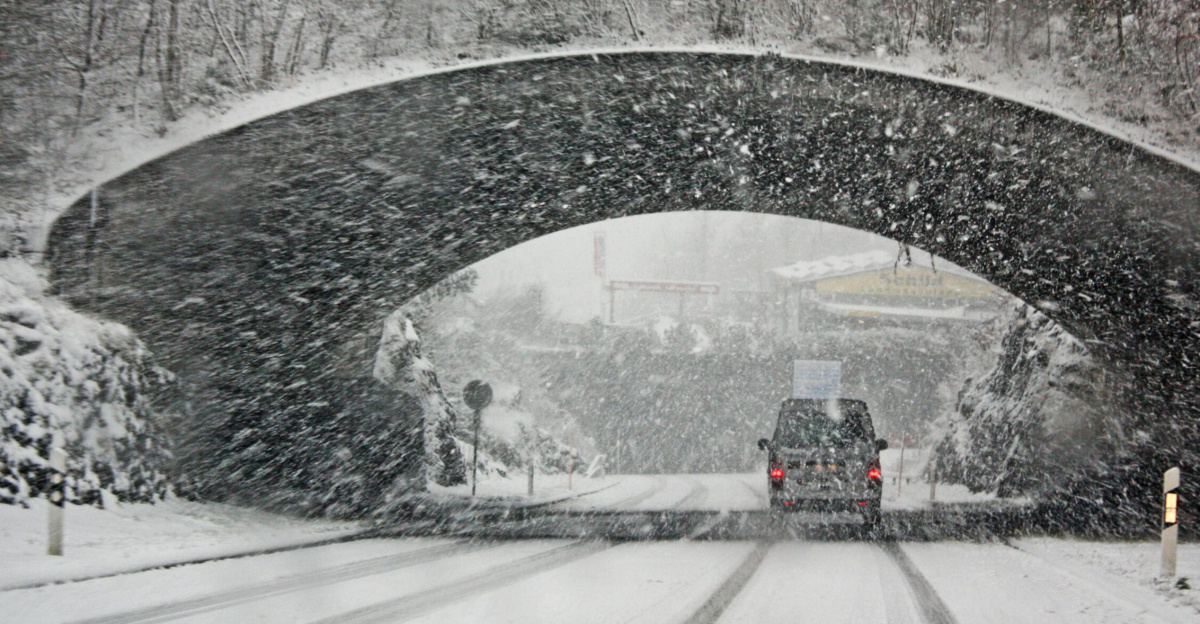 A winter storm covers a Swiss bridge in snow, creating a beautiful yet hazardous landscape.