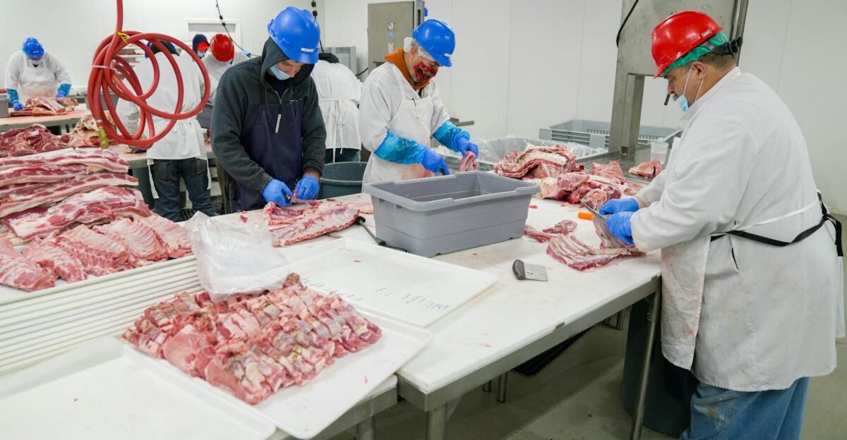Butchers expertly processing meat in a USDA-inspected facility Hygiene and precision are prioritized