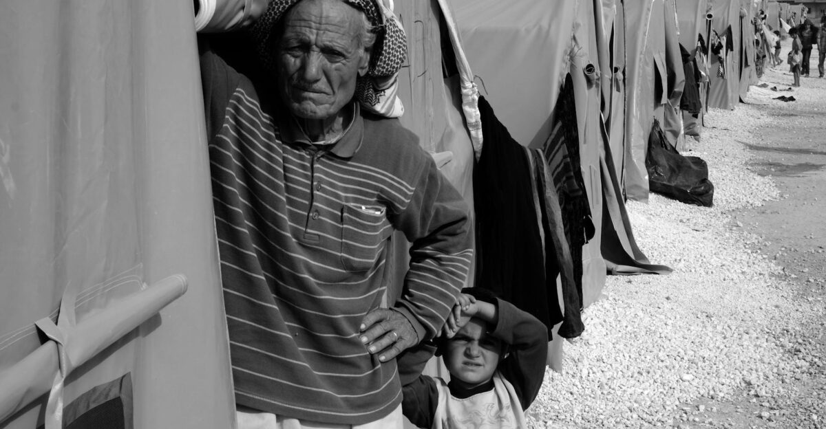 Black and white image of refugees in a camp highlighting humanity and resilience
