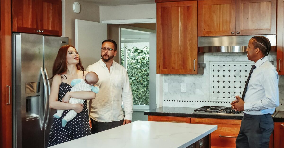 Couple with baby exploring a kitchen with a real estate agent