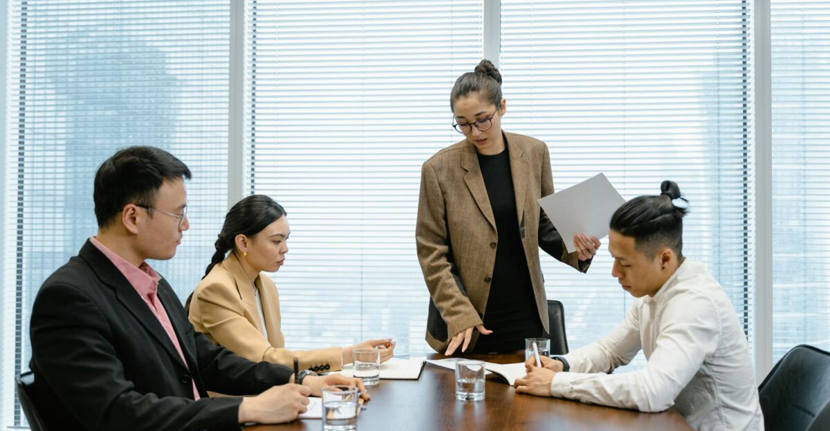Business colleagues engaged in a meeting around a wooden table within a modern office