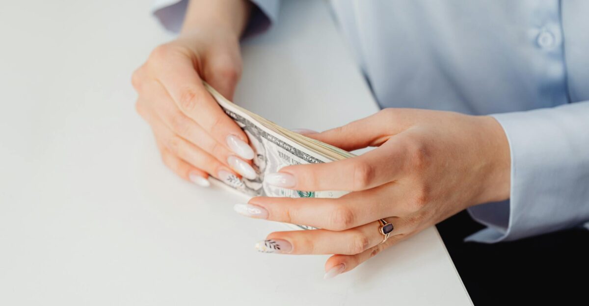 Close-up of hands holding US dollar bills showcasing financial concept
