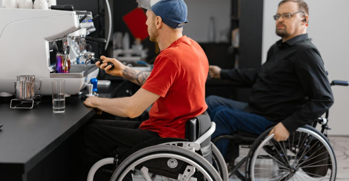 Two men in wheelchairs work at a coffee shop showcasing inclusivity in the workplace