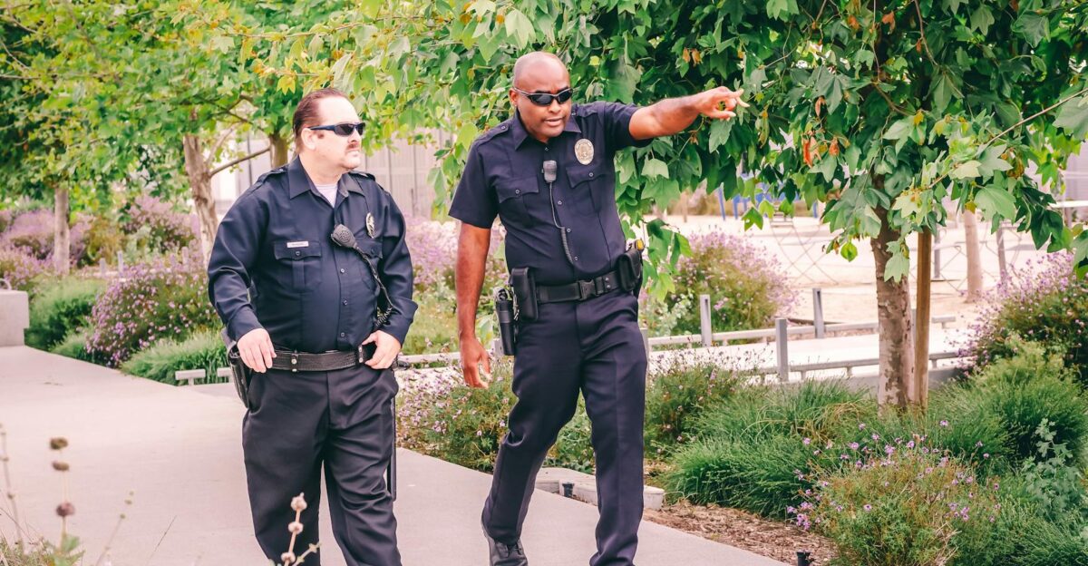 Two police officers walking along a park path in uniform ensuring public safety