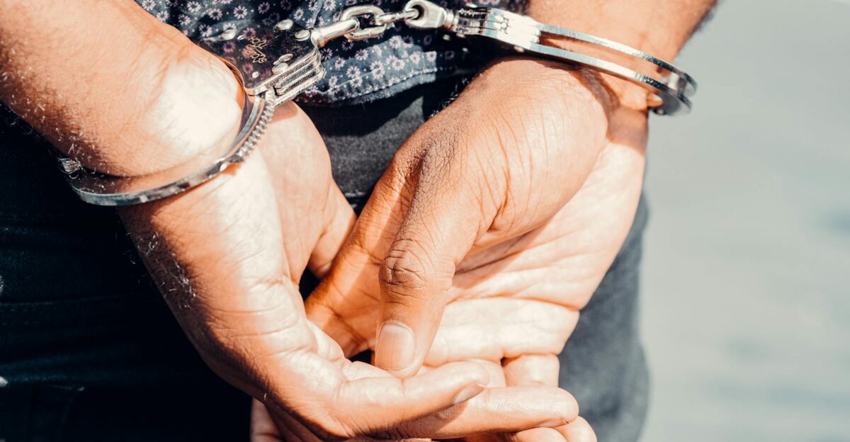 Close-up of an adult male s hands in handcuffs symbolizing law enforcement and justice