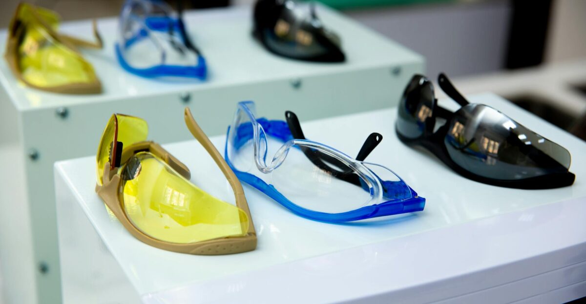 Close-up of different colored protective eyewear on display featuring yellow blue and black designs