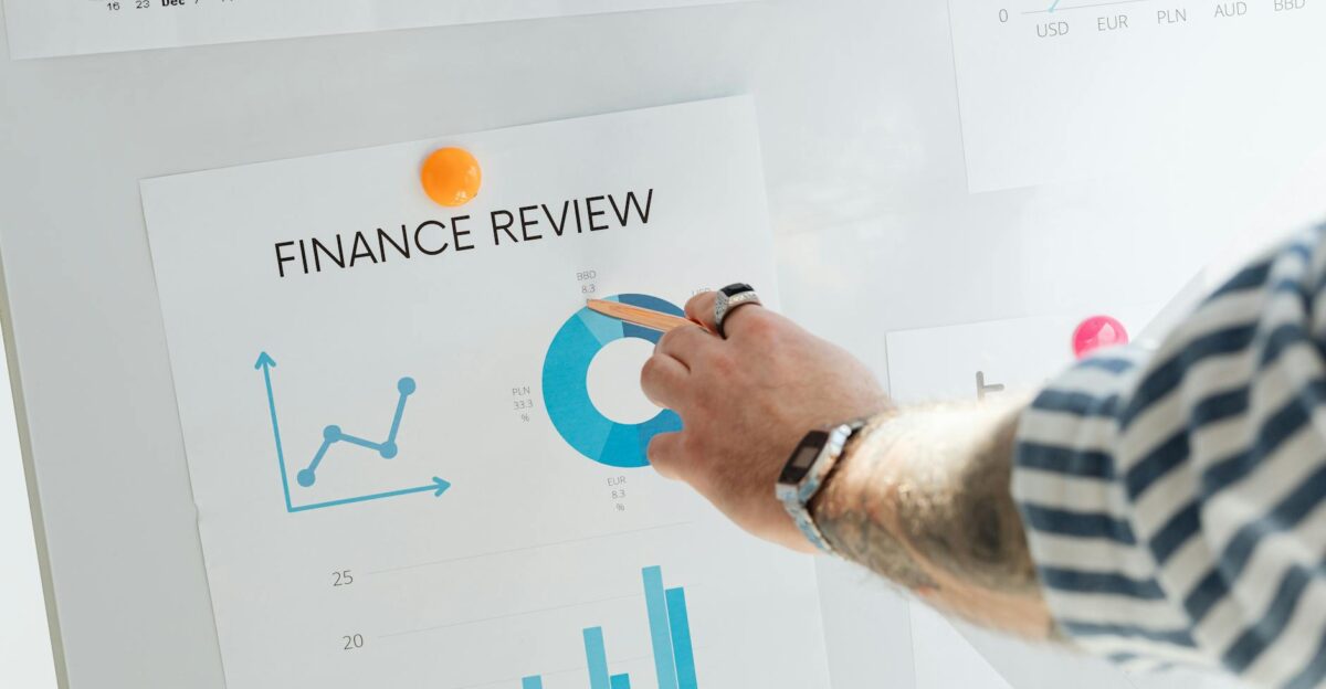 Close-up of a hand pointing to financial charts during a business review